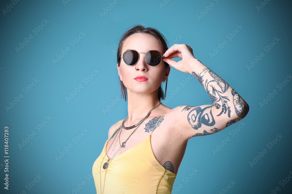 custom made wallpaper toronto digitalBeautiful young woman with tattoo wearing sunglasses and posing on blue background