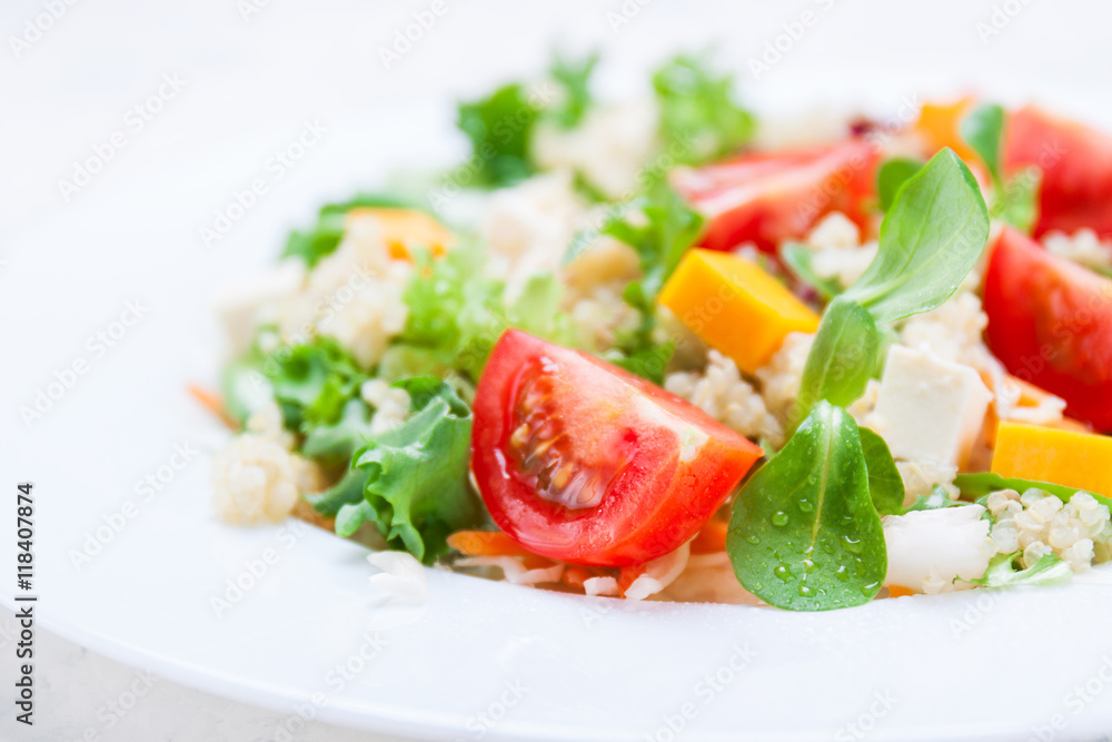Homemade autumn healthy salad with quinoa, salad leaves, tomatoes, pumpkin and feta cheese on a white plate, closeup, selective focus Homemade autumn healthy salad with quinoa, salad leaves, tomatoes, pumpkin and feta cheese on a white plate, closeup, selective focus