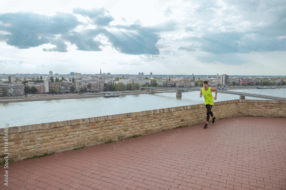 Young man fitness jogging city panorama