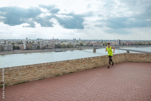 Young man fitness jogging city panorama