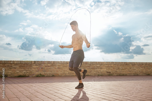 young man shirtless abs fit jumping rope