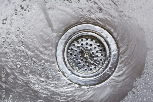 Konstfotografi Water flowing going down drain in stainless steel kitchen sink