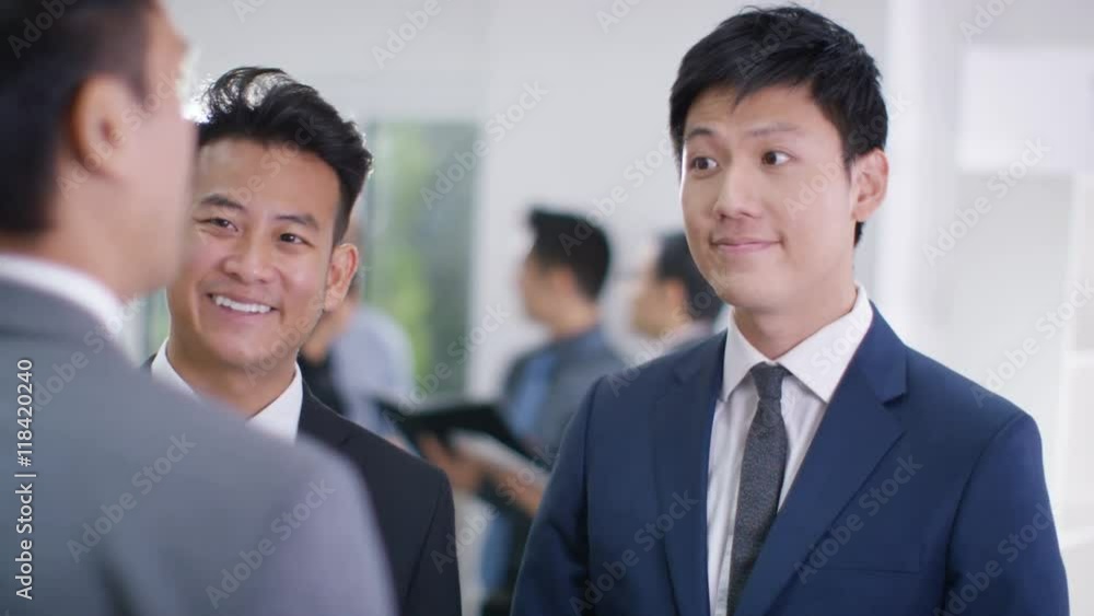 Smiling Asian business group shake hands & discuss business Smiling Asian business group shake hands & discuss business