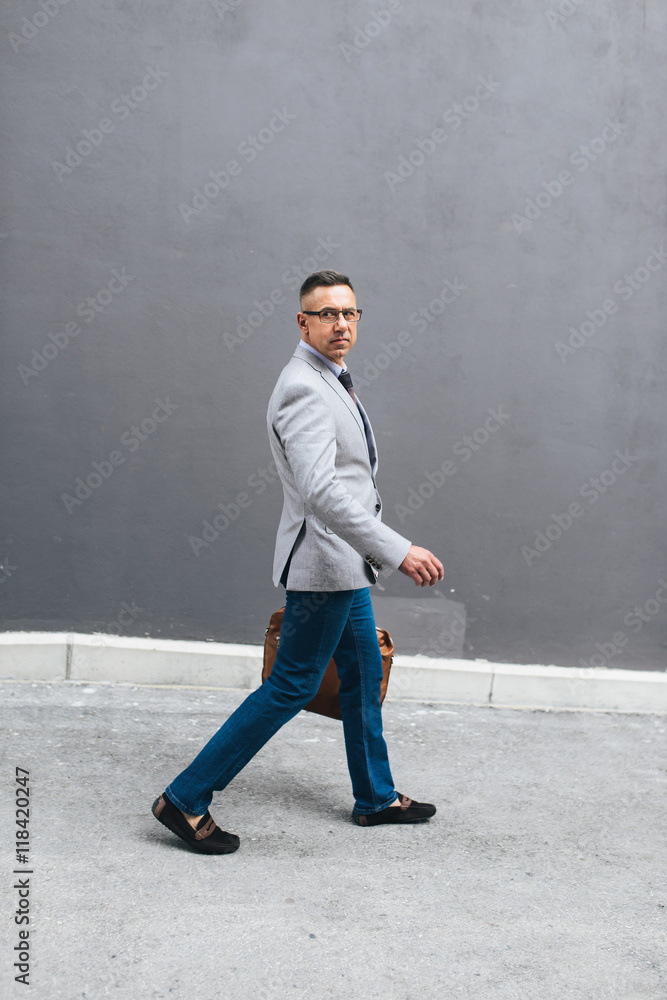 Shot of a stylish mature man crossing a city street and looking at the camera. On the way to meeting Shot of a stylish mature man crossing a city street and looking at the camera. On the way to meeting