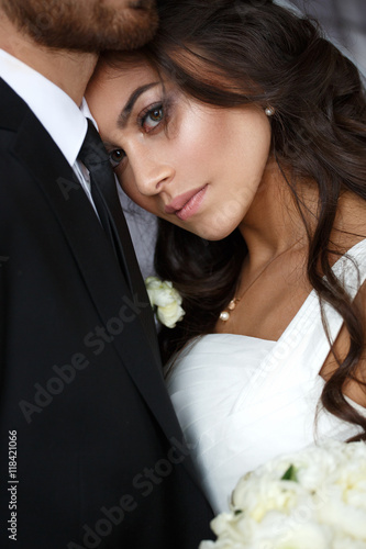 Schilderij op canvas Tender wedding photo session indoor of the elegant bride in a white dress and gr