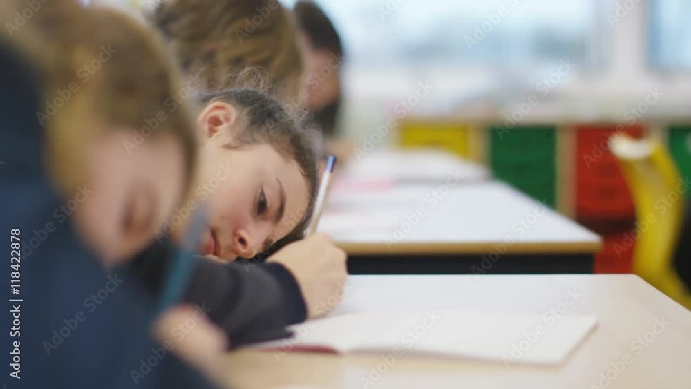 Young students working at their desks in school classroom. Young students working at their desks in school classroom.