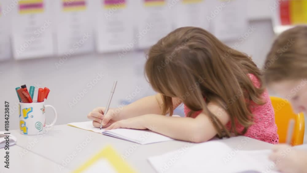 Young pupils working at their desks in school classroom Young pupils working at their desks in school classroom
