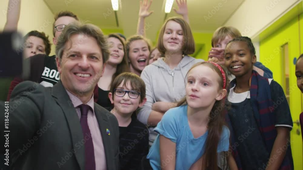 Happy teacher & pupils pose for selfie in school hallway. Happy teacher & pupils pose for selfie in school hallway.
