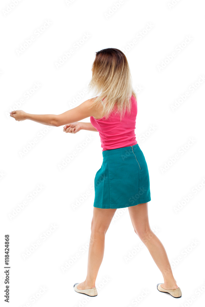 back view of standing girl pulling a rope from the top or cling to something. girl  watching. Rear view people collection.  backside view of person.  Isolated over white background. Blonde in a red