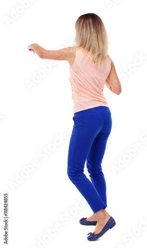 back view of standing girl pulling a rope from the top or cling to something. girl watching. Rear view people collection. backside view of person. Isolated over white background. The blonde in a