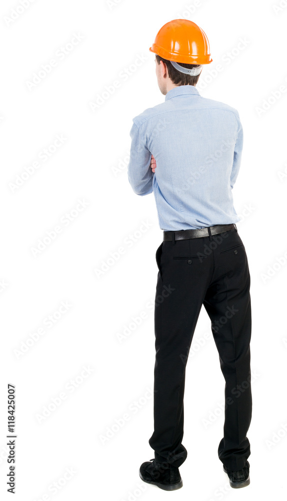 Backview of an engineer in construction helmet stands. Standing young guy. Rear view people collection. backside view of person. Isolated over white background. Curly businessman in a light jacket Backview of an engineer in construction helmet stands. Standing young guy. Rear view people collection. backside view of person. Isolated over white background. Curly businessman in a light jacket