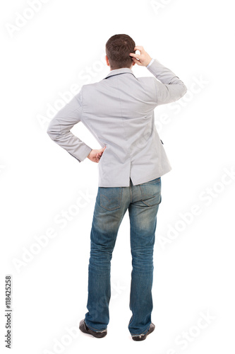 Back view of man . Standing young guy. Rear view people collection. backside view of person. Isolated over white background. A guy in a gray jacket thoughtfully scratches his head.
