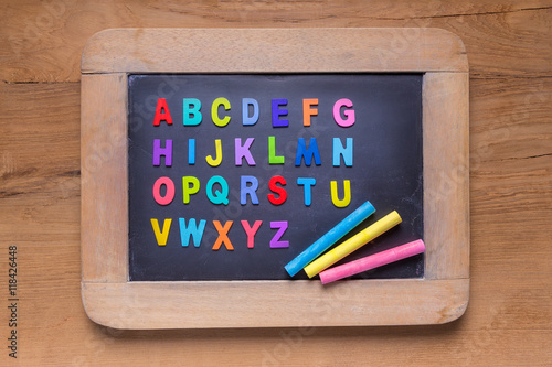 Small blackboard with color chalks and color English alphabets o