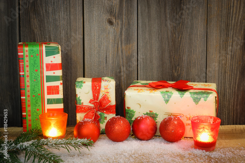 Weihnachtspäckchen dekorativ vor einer Holzwand aufgestellt photo