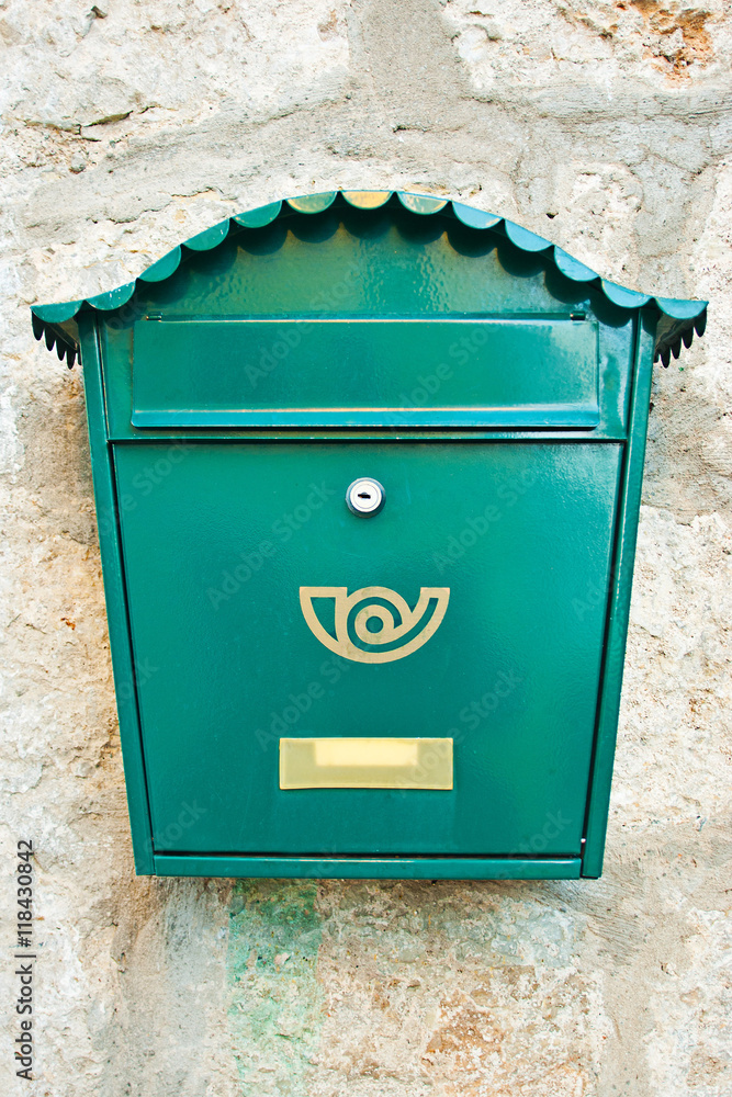 Green mailbox on a wall background