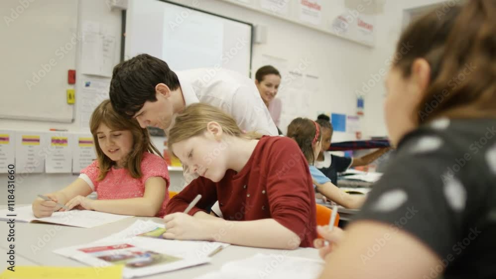 Teacher working with young students in school lesson Teacher working with young students in school lesson