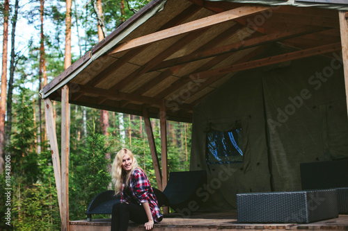 beautiful girl sitting in a large tent in the woods