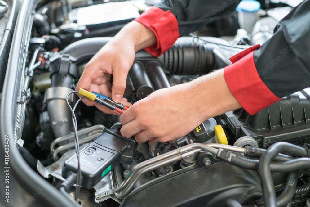 Car mechanic measures the values Car mechanic measures the values