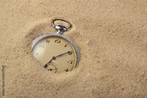 Antique pocket watch in sand