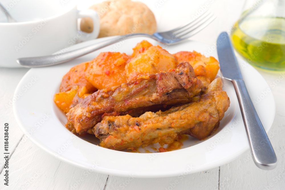 serving of pork stew in white dish on wooden board serving of pork stew in white dish on wooden board