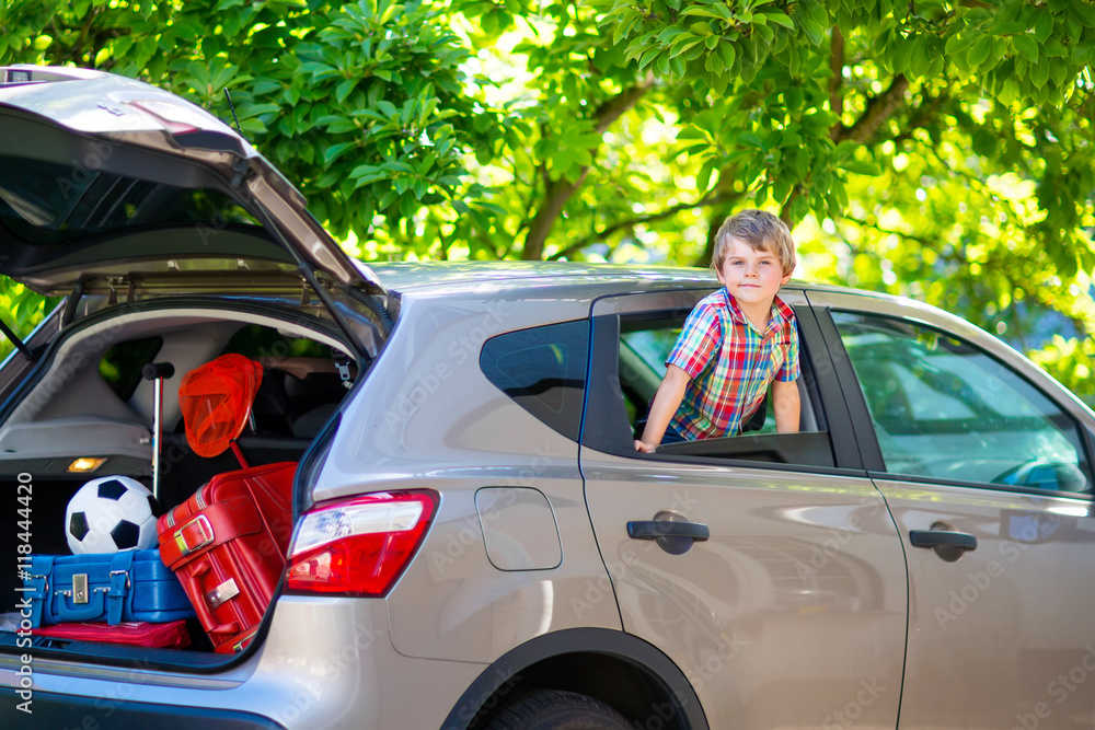 little kid boy sitting in car  just before leaving for vacation