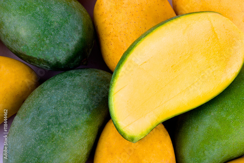 a pile yellow ripe mango and fresh green mango and half mango  on white background healthy fruit food isolated
