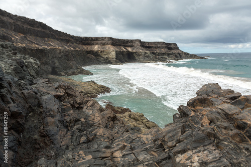 Wave splashing over a rock on the beach of Puertito de los Molinos on Fuerteventura. Canary Island  Spain