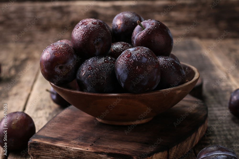 Obraz premium ripe plums on wooden vintage background