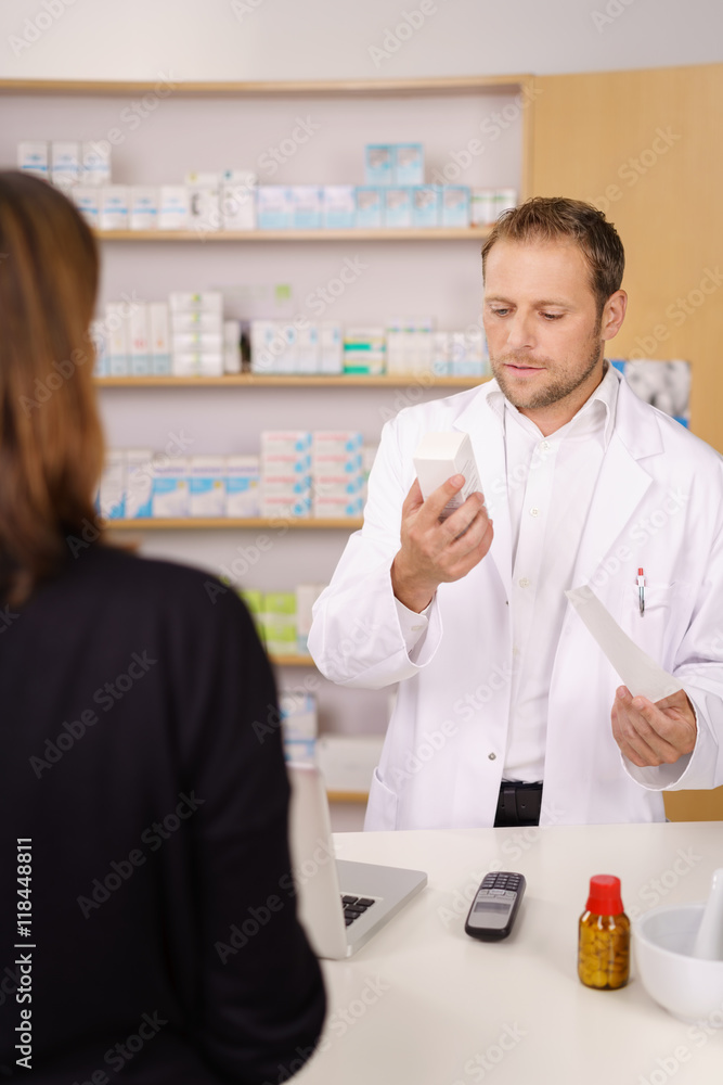 apotheker schaut auf die verpackung eines medikaments apotheker schaut auf die verpackung eines medikaments
