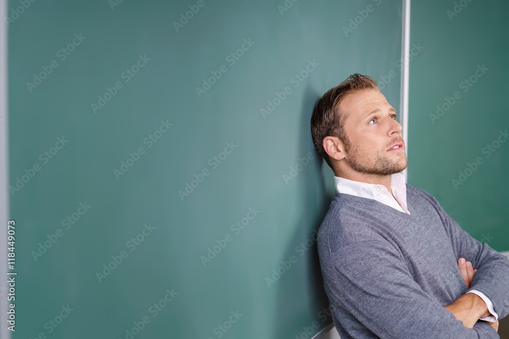 lehrer lehnt an der tafel und schaut nachdenklich nach oben