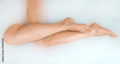 Beautiful woman legs in bath with milk. SPA treatments for skin care.