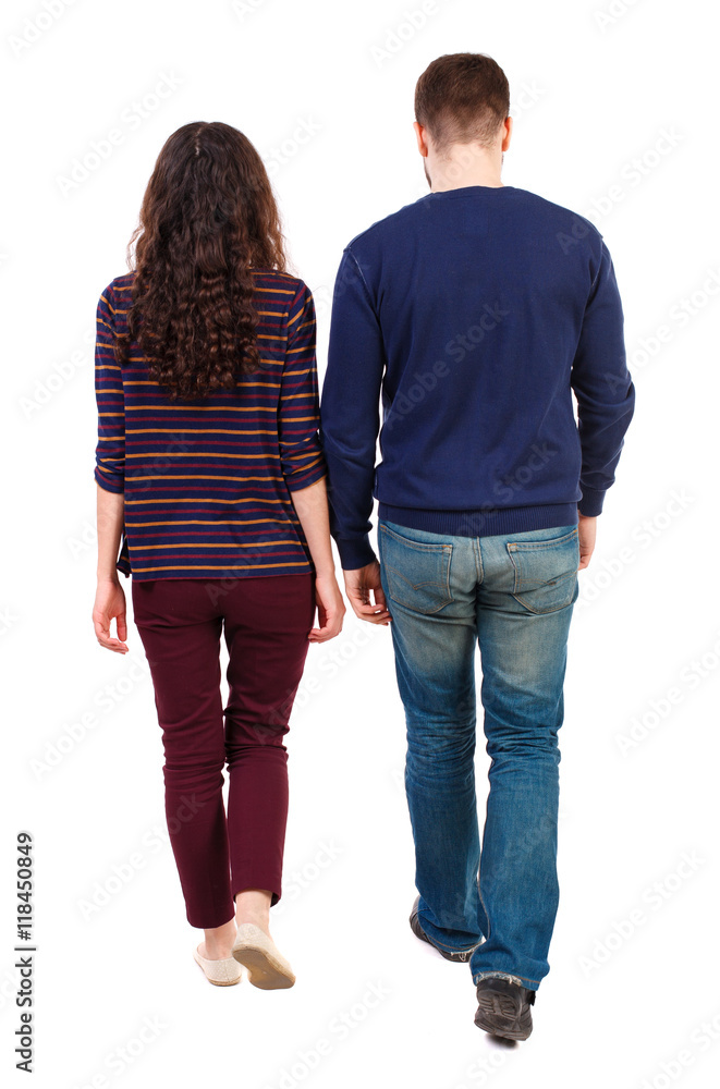 Back view going couple. walking friendly girl and guy holding hands