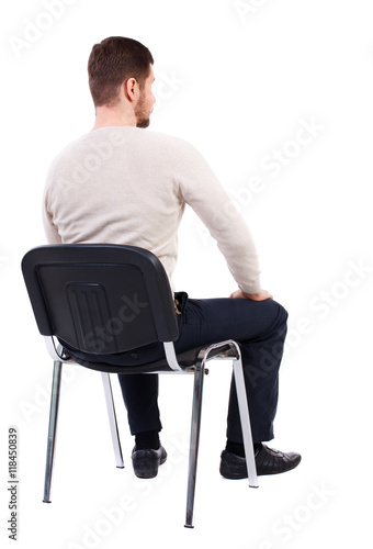 back view of business man sitting on chair.  businessman watching. Rear view people collection.  backside view of person.  Isolated over white background. The bearded man in a white warm sweater sits