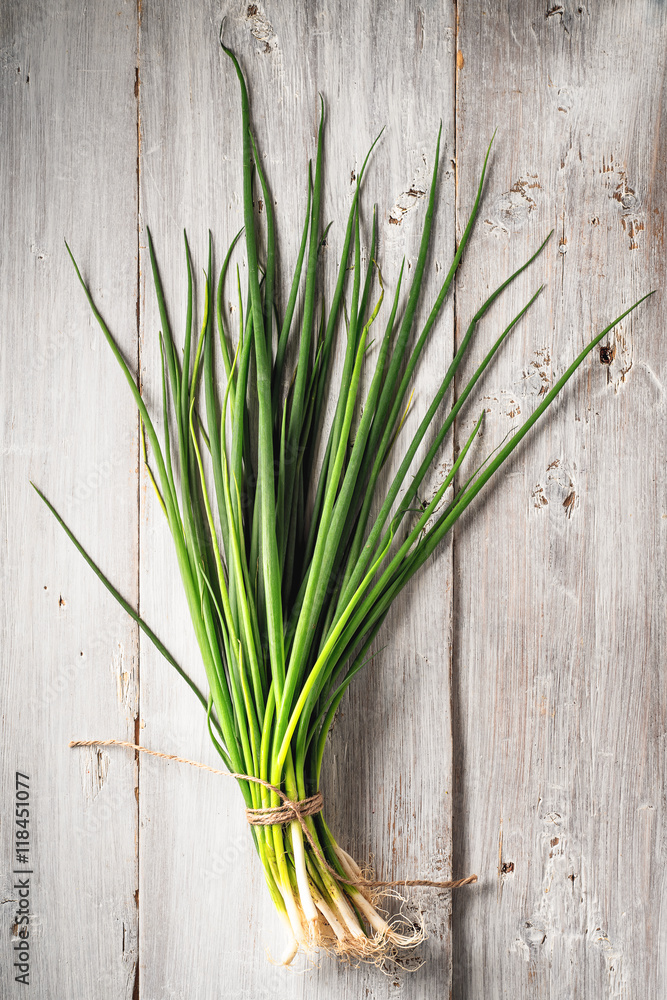 Green onion on the white wooden table vertical Green onion on the white wooden table vertical