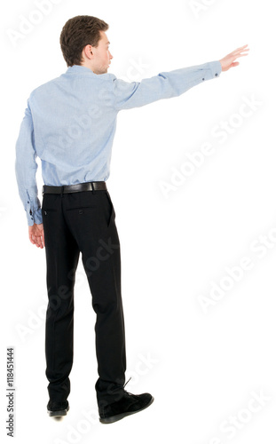 Back view of pointing business man. Rear view people collection. backside view of person. Isolated over white background. Businessman in a shirt and a bow tie is back and shows his hand.