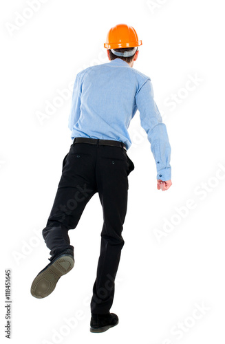 Back view of running engineer in helmet. Walking guy in motion. Rear view people collection. Backside view of person. Isolated over white background. Businessman in a blue shirt and a helmet moves © ghoststone