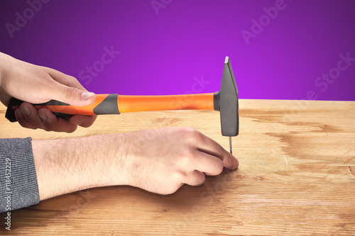 man hammers a nail with a hammer