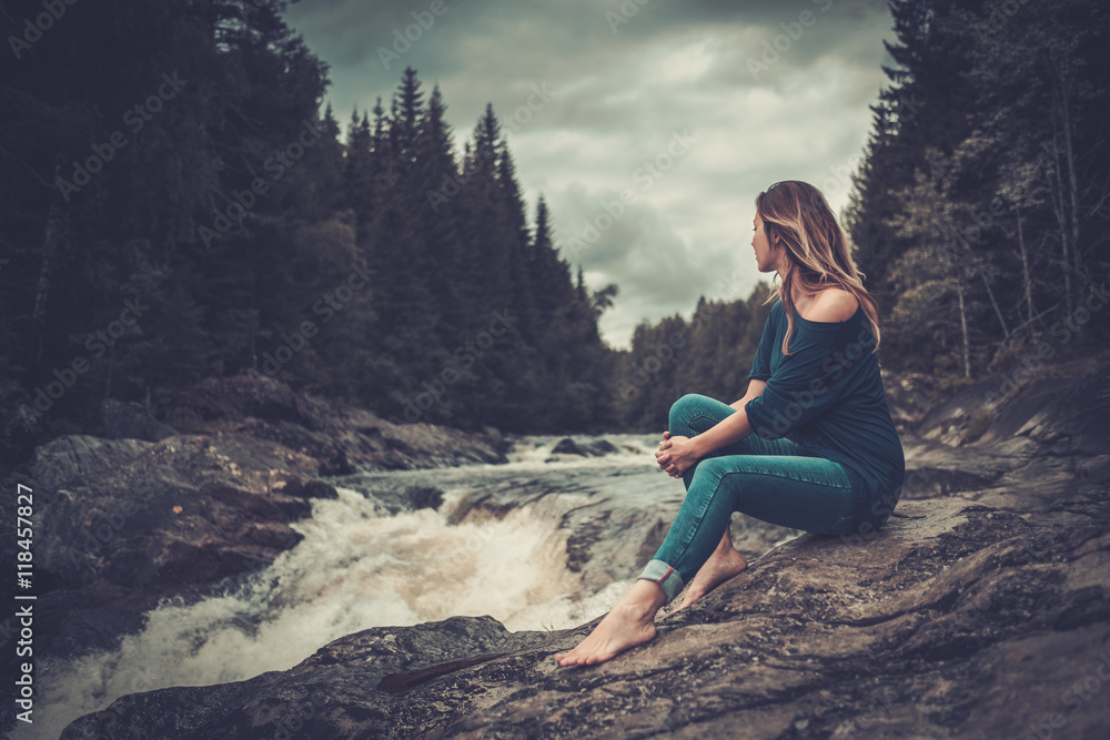 Beautiful woman posing near waterfall with mountain forest on the background. - obrazy, fototapety, plakaty 