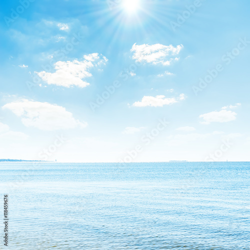 blue seascape with sun over clouds