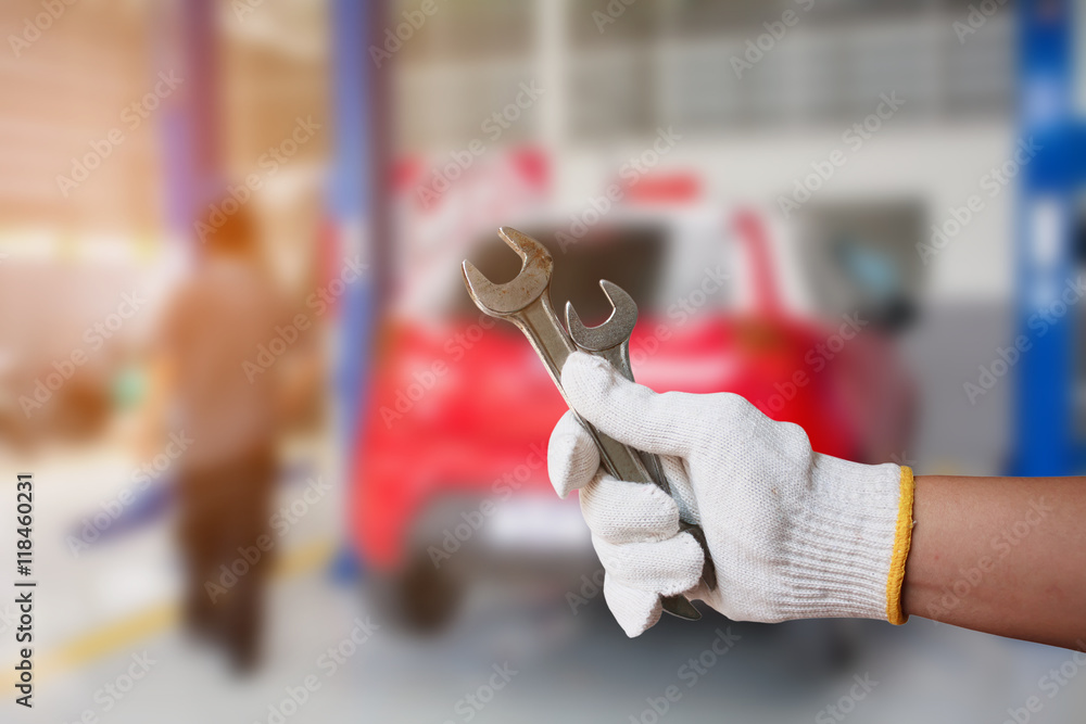 Car mechanic holding wrench at the car repair garage Car mechanic holding wrench at the car repair garage