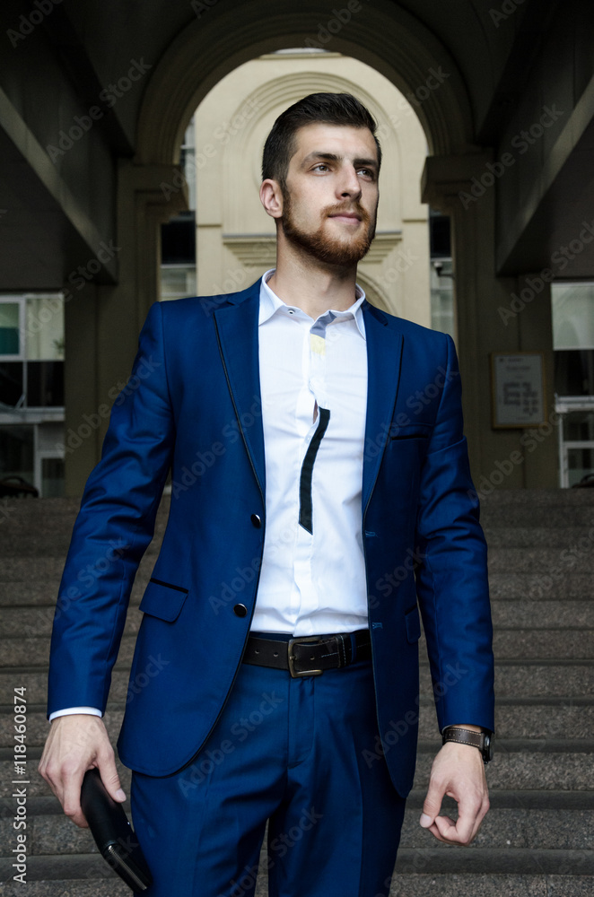 Handsome man in the jacket on a building background