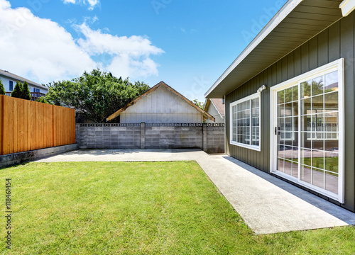 Back yard house exterior with wooden fence and well kept lawn around