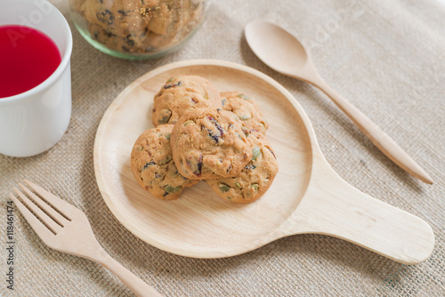 Oat cookies with pumpkin seeds and raisin on a wooden plate.