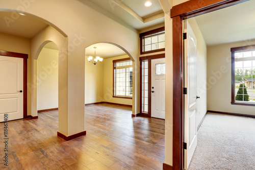 Hallway interior with columns, hardwood floor and carpet floor.