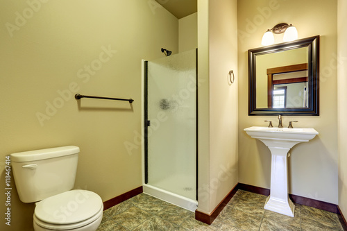 Bathroom interior with tile floor  sink  toilet and glass shower door.