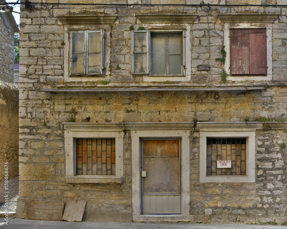 An historic old derelict building in Skradin old town, Sibenik-Knin County, Croatia. The sign on the window announces that the building is for sale.

