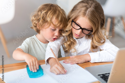 Girl and boy drawing in notebook