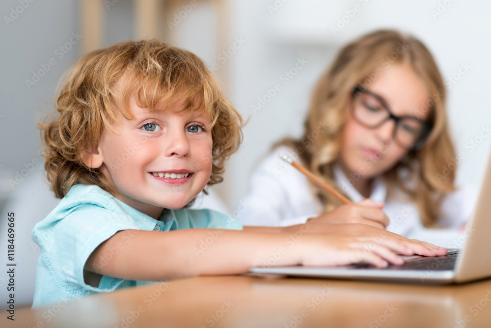 Smiling boy working on laptop Smiling boy working on laptop