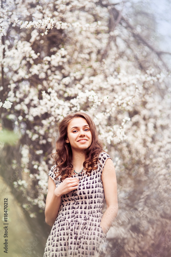 Beautiful Girl standing in the blooming of cherry flowers Beautiful Girl standing in the blooming of cherry flowers