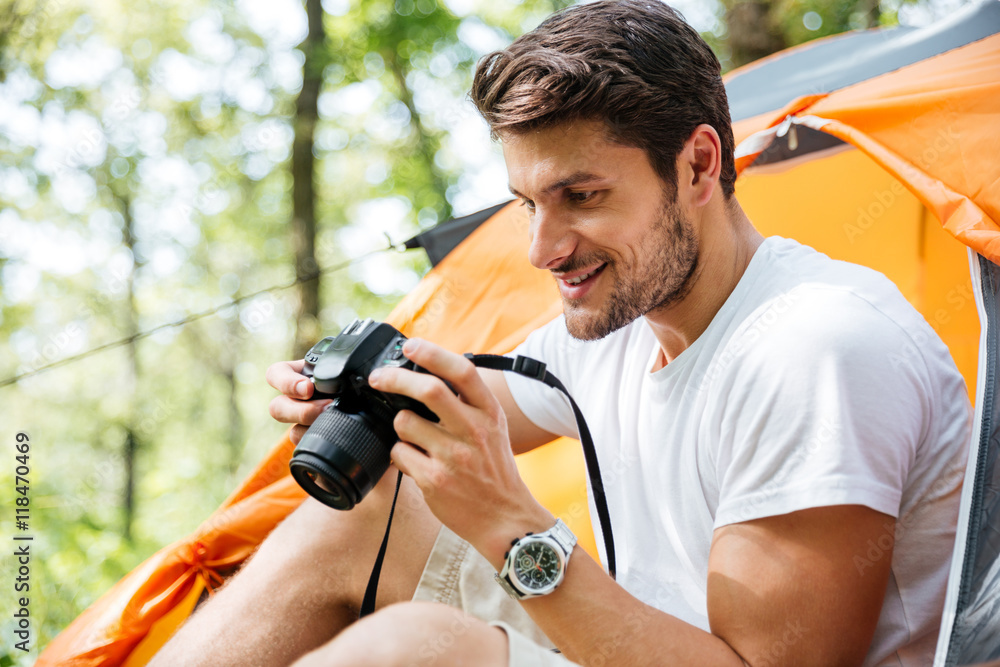 Man tourist taking photos with modern photo camera in forest Man tourist taking photos with modern photo camera in forest